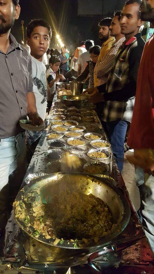 Volunteers serving a meal to people in a queue