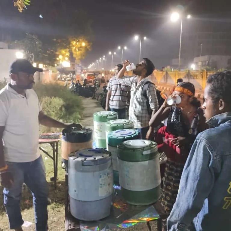 Volunteers serving drinking water during night seva